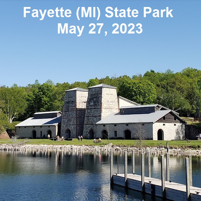 Image: furnace complex at the ghost town of Fayette, Michigan. Image is dominated by twin furnace stacks, which look like fat obelisks made of limestone. On either side of the furnace stacks are casting rooms, tall one-story buildings made of limestone with wide arched doors.
Text over image: Fayette (MI) State Park 27 May 2023
