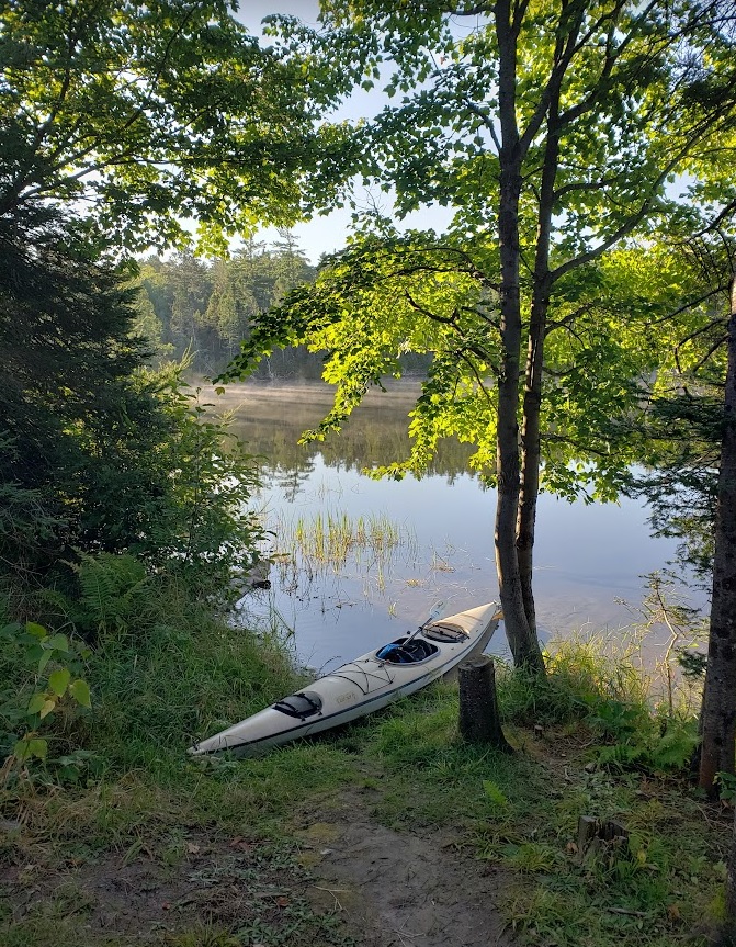 image of the author's kayak, which he affectionately refers to by the name Dawdle, beached on the shore of his camp site on Star Lake 