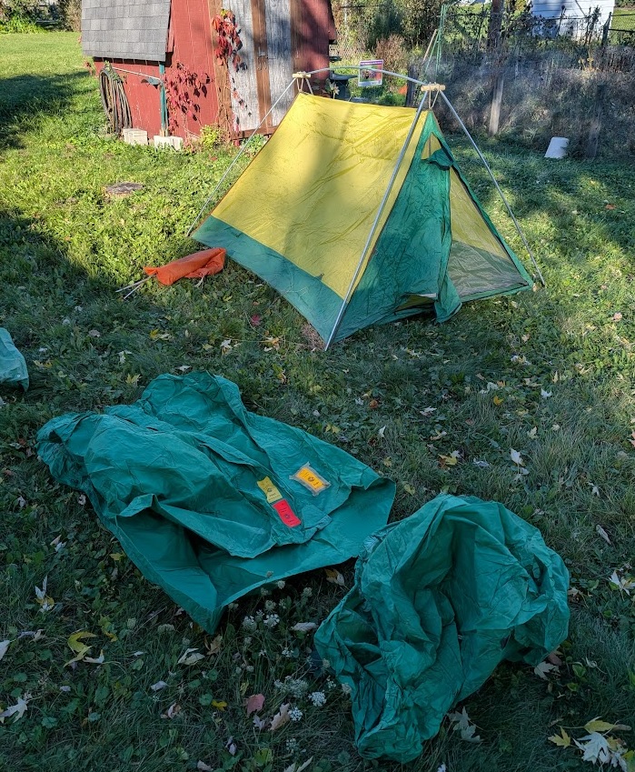 a 50-year-old yellow and green Eureka Timberline tent in the background and the tent fly and vestibule in the foreground