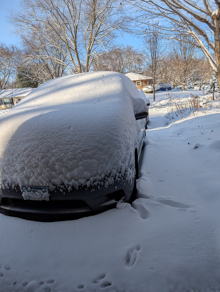 ten inches of new-fallen show turns a Toyota Sienna minivan into a while lump