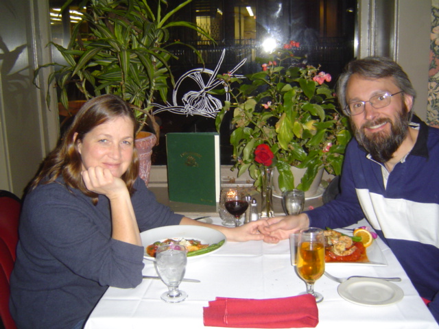 a woman and a man hold hands over a table in a restaurant